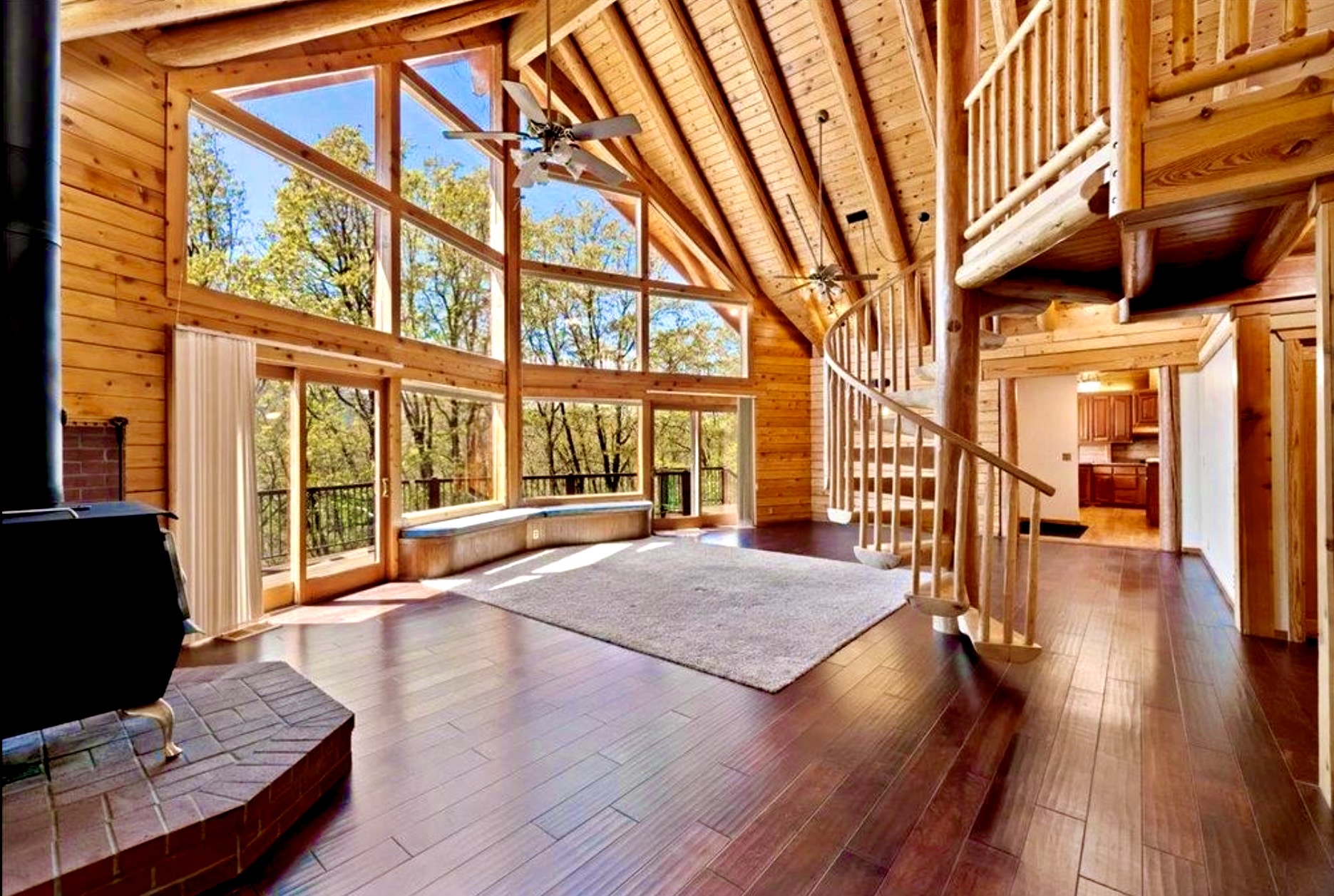 Open living area with wood stove, deck access, and forest views